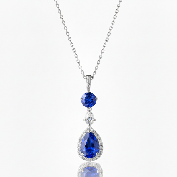 Silver necklace with blue teardrop-shaped gemstones on a white background