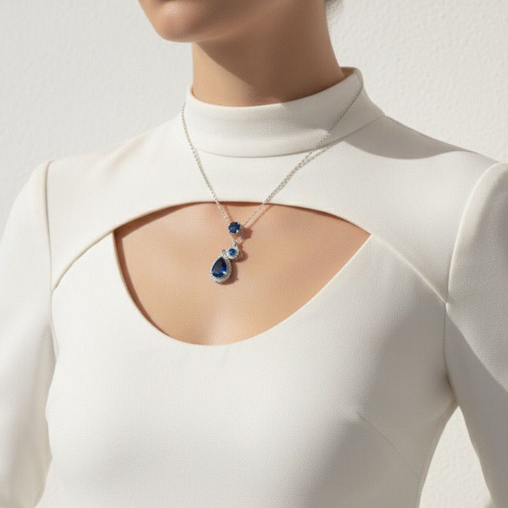 White long-sleeve top with cut-out design and necklace on a neutral background