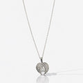 Silver necklace with a leaf-shaped pendant on a white background