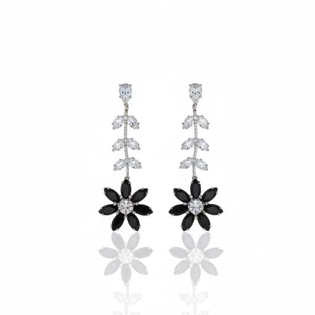 Pair of floral earrings with black and silver details on a white background