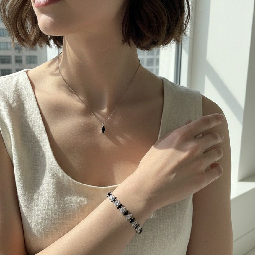 Woman wearing a necklace and bracelet with a neutral background