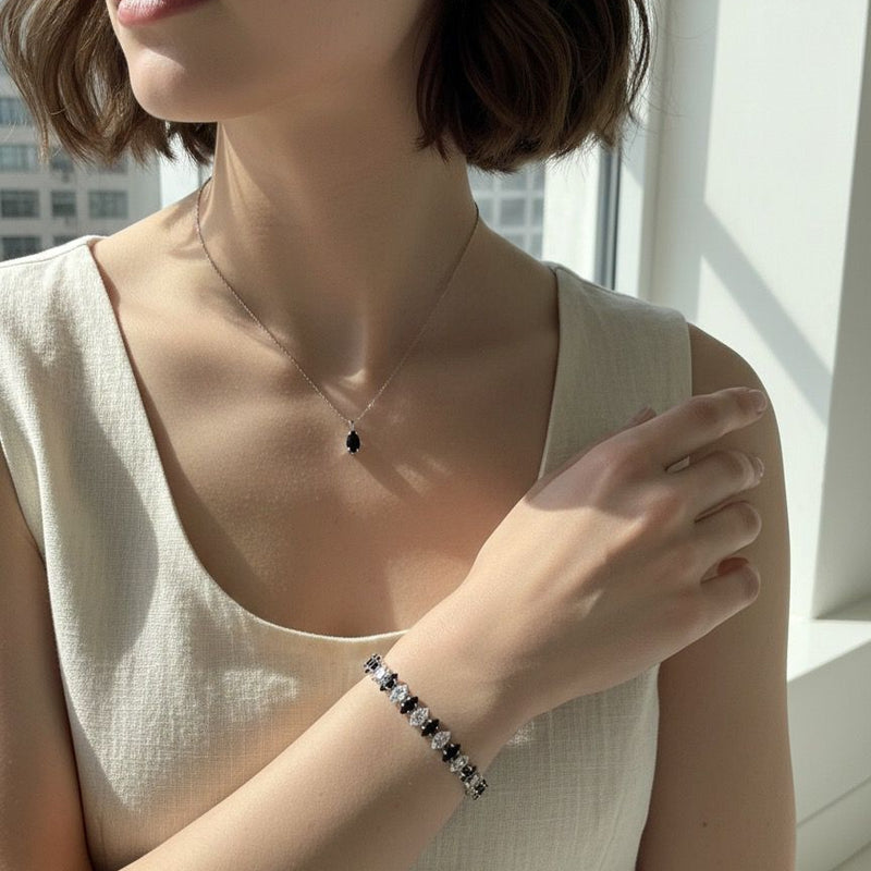 Woman wearing a necklace and bracelet with a neutral background