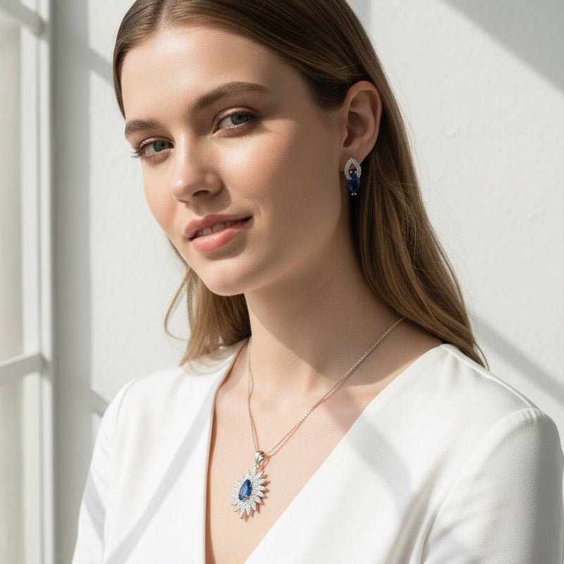 Woman wearing a white outfit with jewelry, standing against a light background