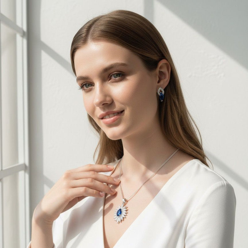 Woman wearing a white outfit with jewelry, standing against a light background