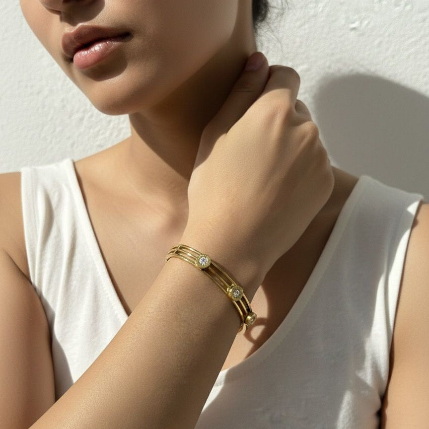 Woman wearing a gold bracelet on a white background