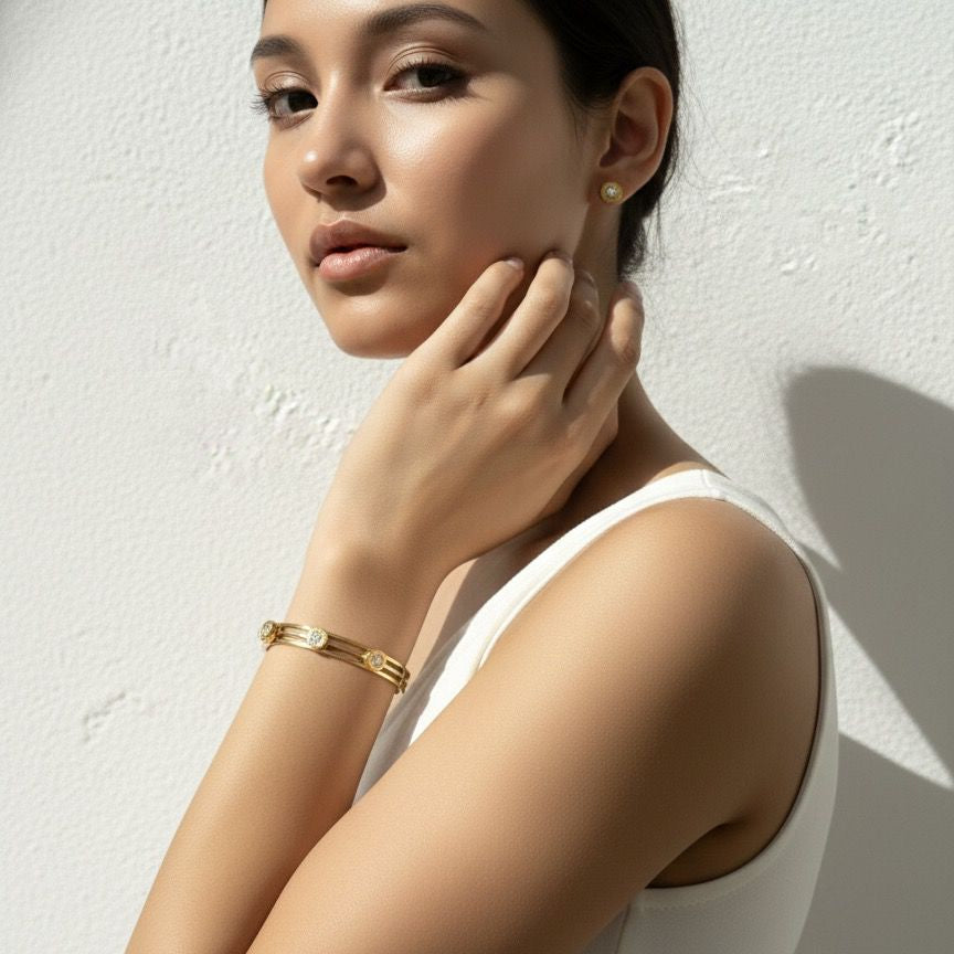 Woman wearing gold jewelry against a white background