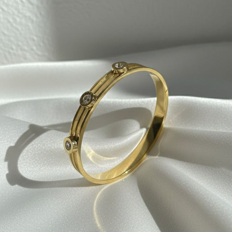 Gold ring with small stones on a white fabric background