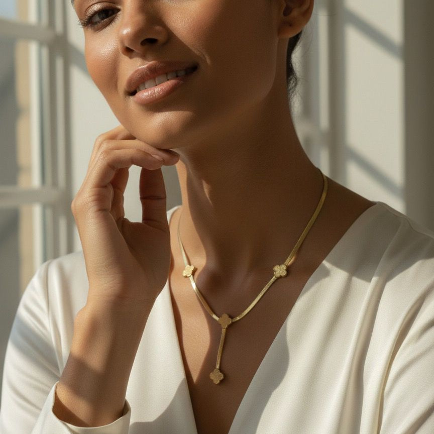 Woman wearing a gold necklace in a softly lit room