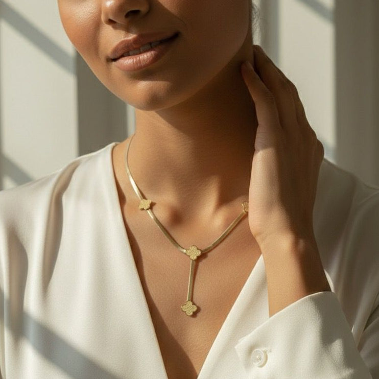 Woman wearing a gold necklace in a softly lit room