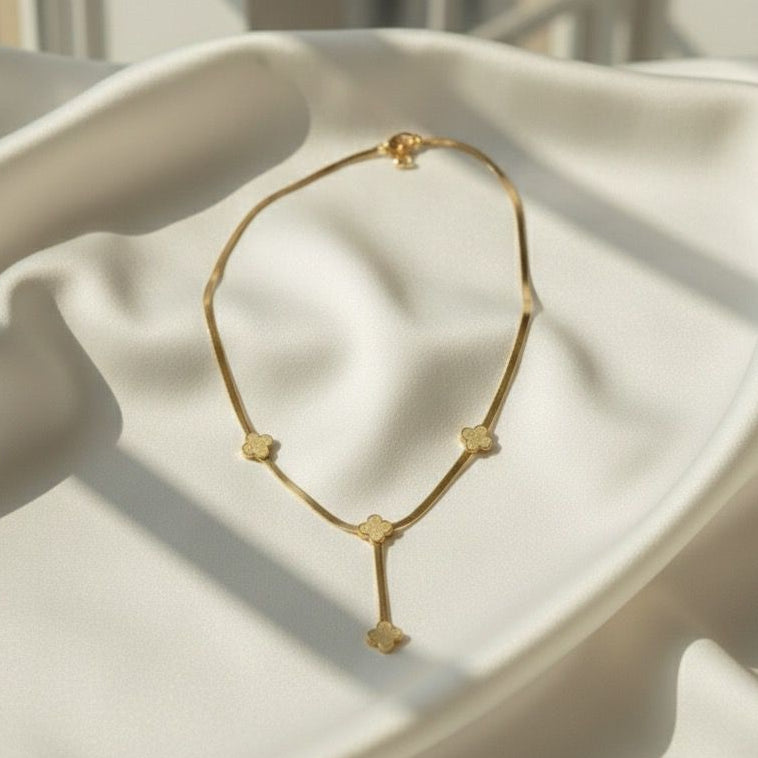 Gold necklace on a white surface with a neutral background