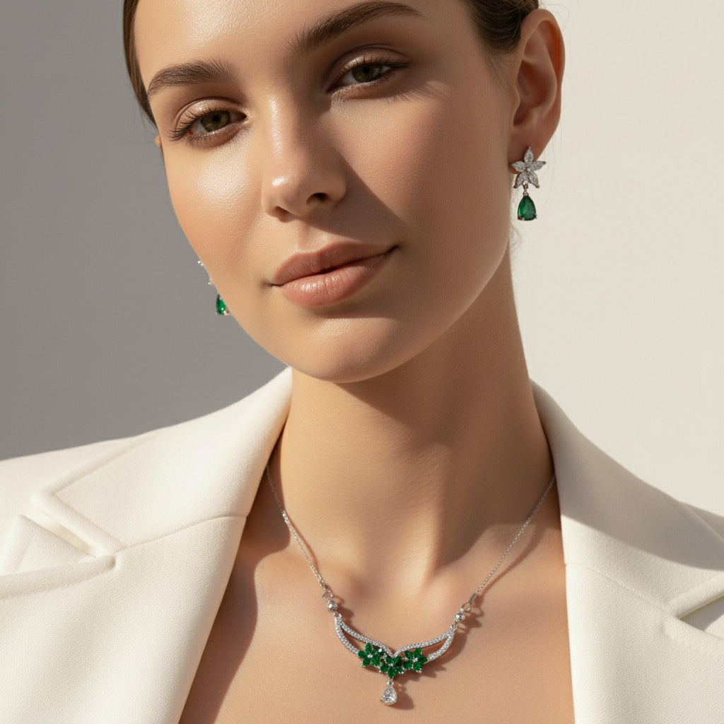 Woman wearing a necklace with emerald green stones against a neutral background