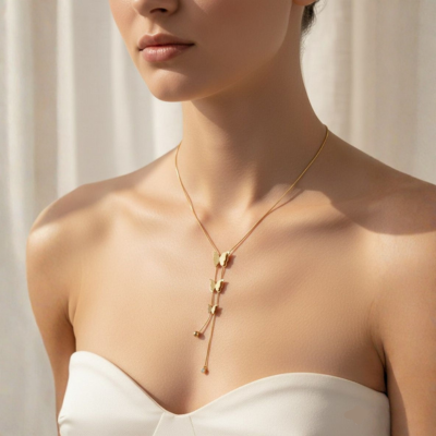 Woman wearing a gold necklace against a neutral background