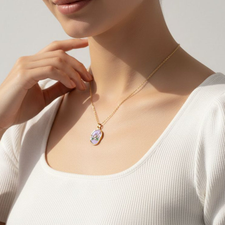 Woman wearing a delicate necklace with a small pendant against a neutral background