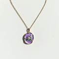 Necklace with a purple pendant on a white background