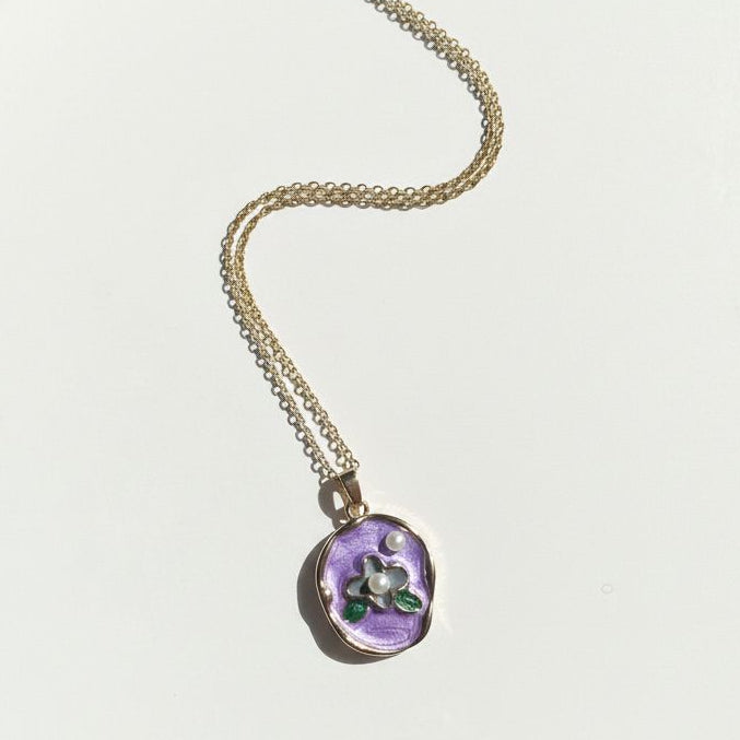Necklace with a purple pendant on a white background