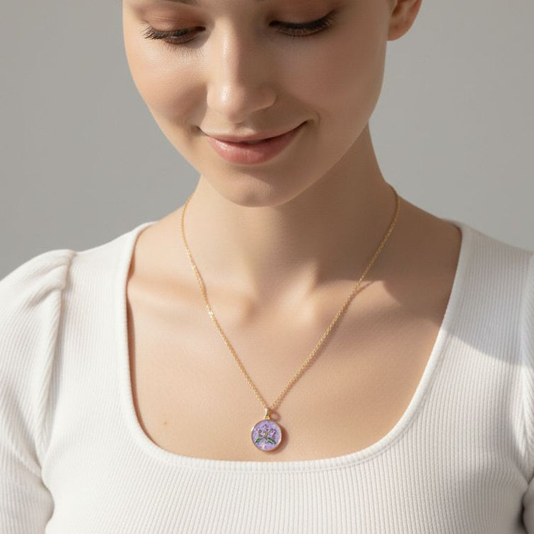 Woman wearing a necklace with a purple pendant against a neutral background
