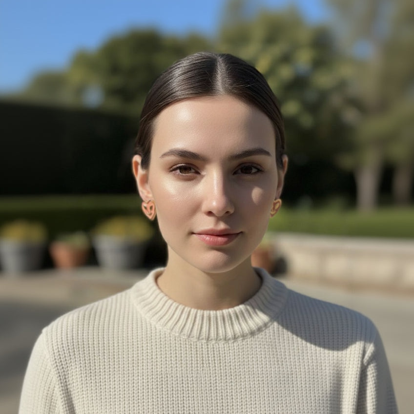 Woman wearing a light-colored sweater with a blurred outdoor background