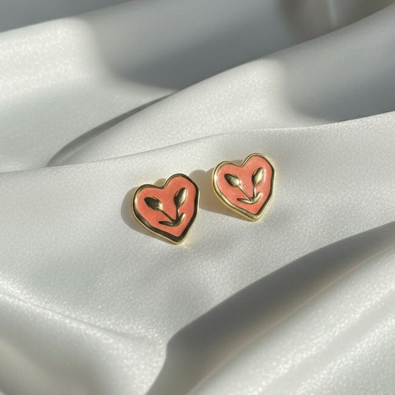 Heart-shaped earrings with gold rims on a satin surface