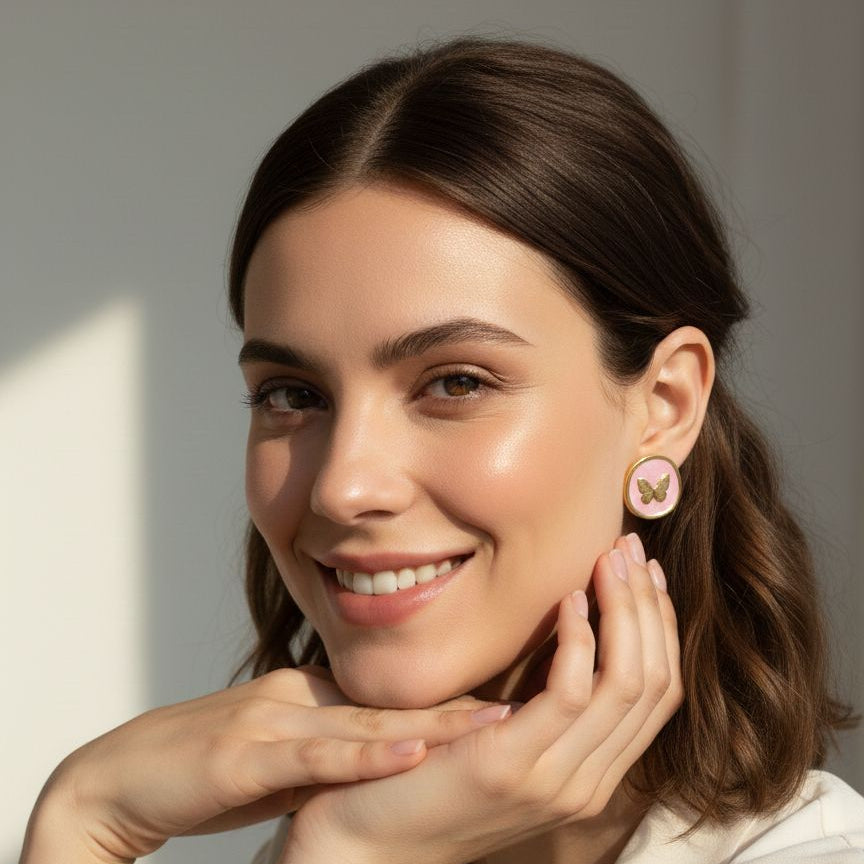 Woman wearing butterfly earrings with a neutral background