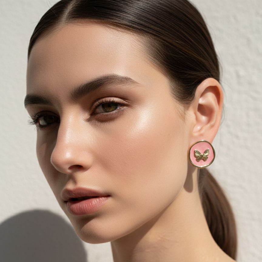 Woman wearing a butterfly-themed earring against a neutral background