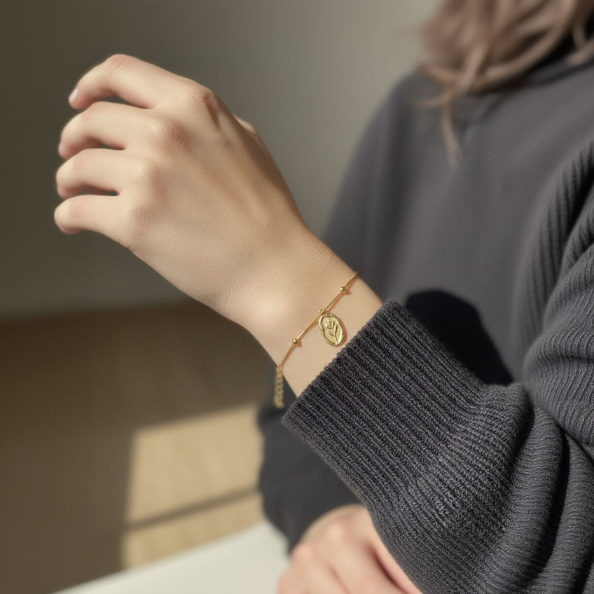 Gold bracelet on a person's wrist with a blurred background