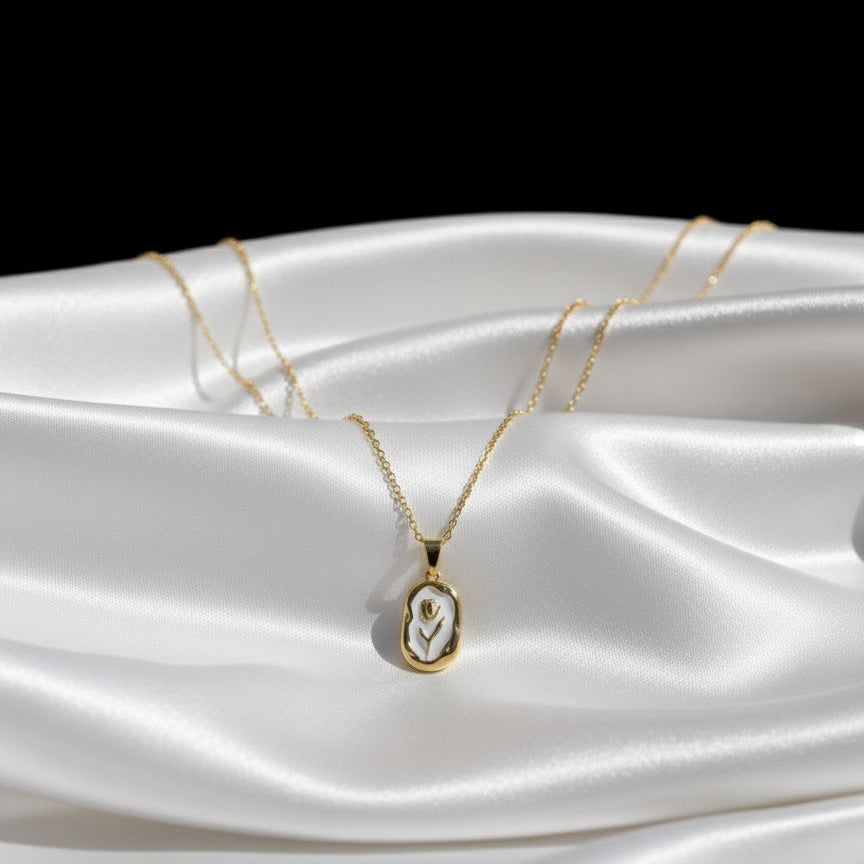 Gold necklace with a pendant on a white satin surface