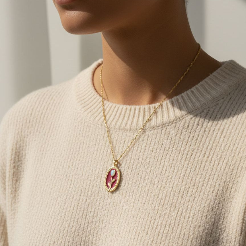 Necklace with a pendant worn by a person in a beige sweater
