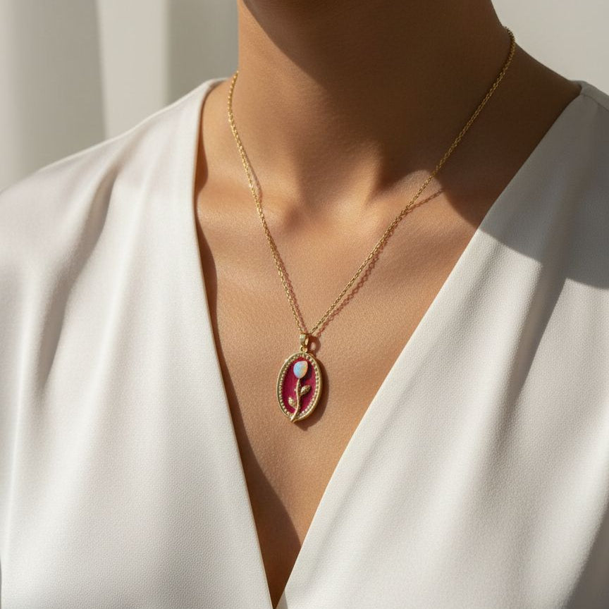 Necklace with a pendant worn by a person in a white outfit