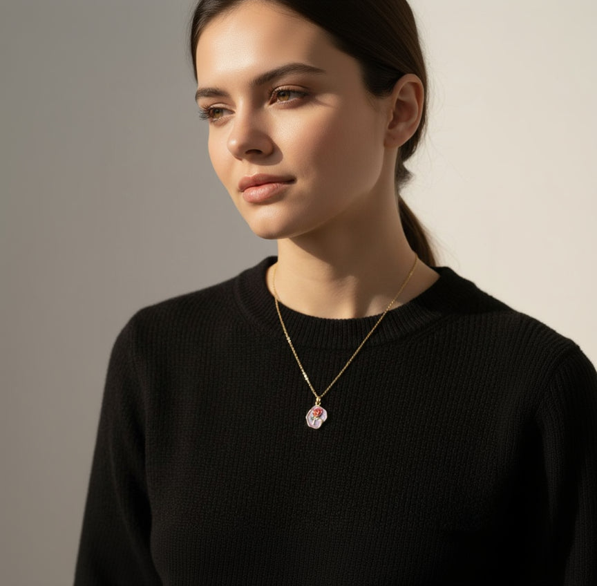 Woman wearing a gold necklace with a pendant against a neutral background