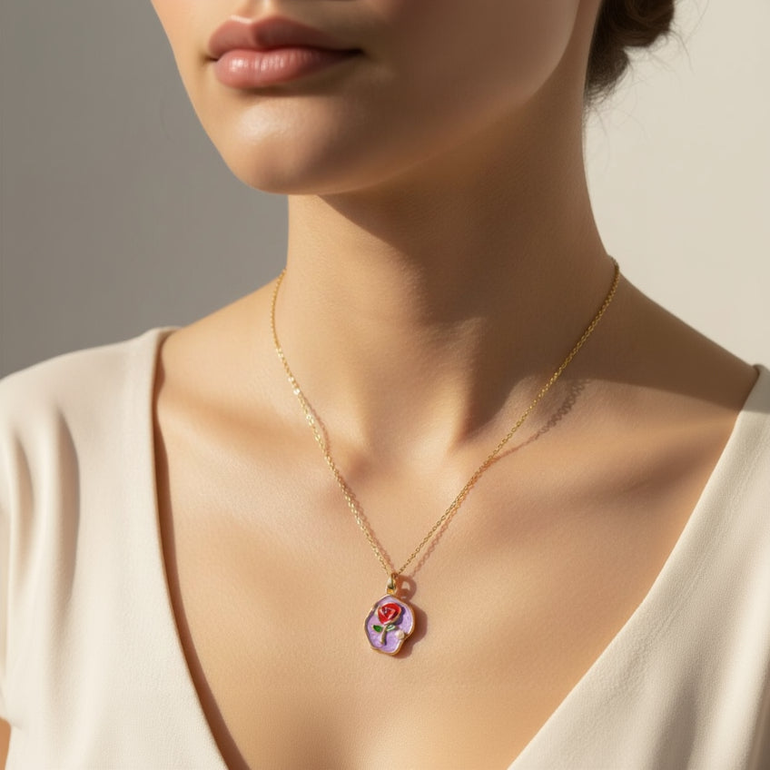 Gold necklace with a rose pendant on a neutral background