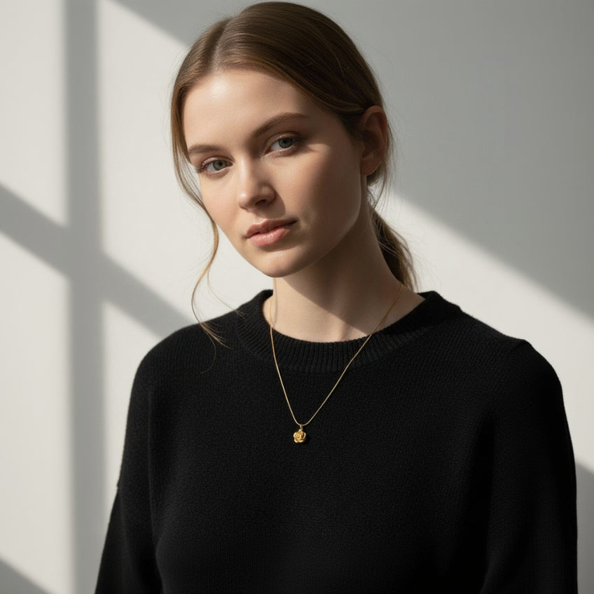 Woman wearing a gold necklace against a neutral background