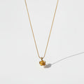 Gold necklace with a small pendant on a white background