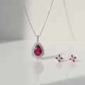 Silver necklace with a red gemstone pendant on a white background