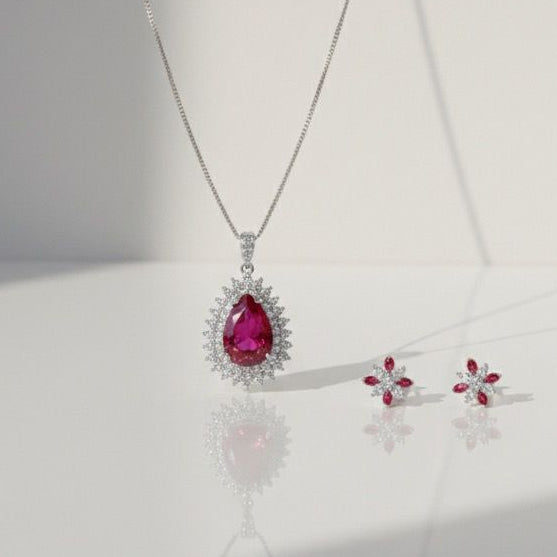 Silver necklace with a red gemstone pendant on a white background