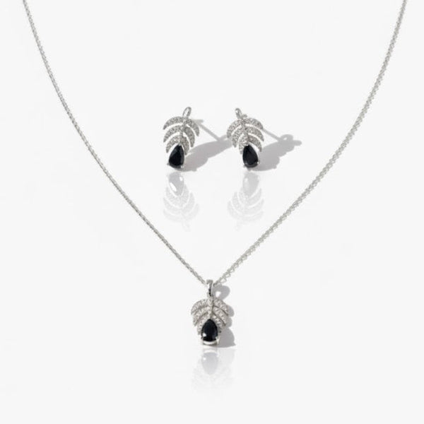 Silver necklace and earrings with black stones on a white background